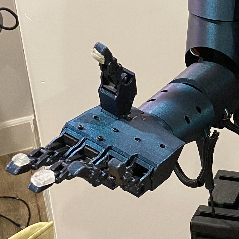 Blue robotic hand mounted on the humanoid arm